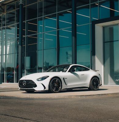 White colour Mercedes Benz AMG GT is parked in front of the showroom