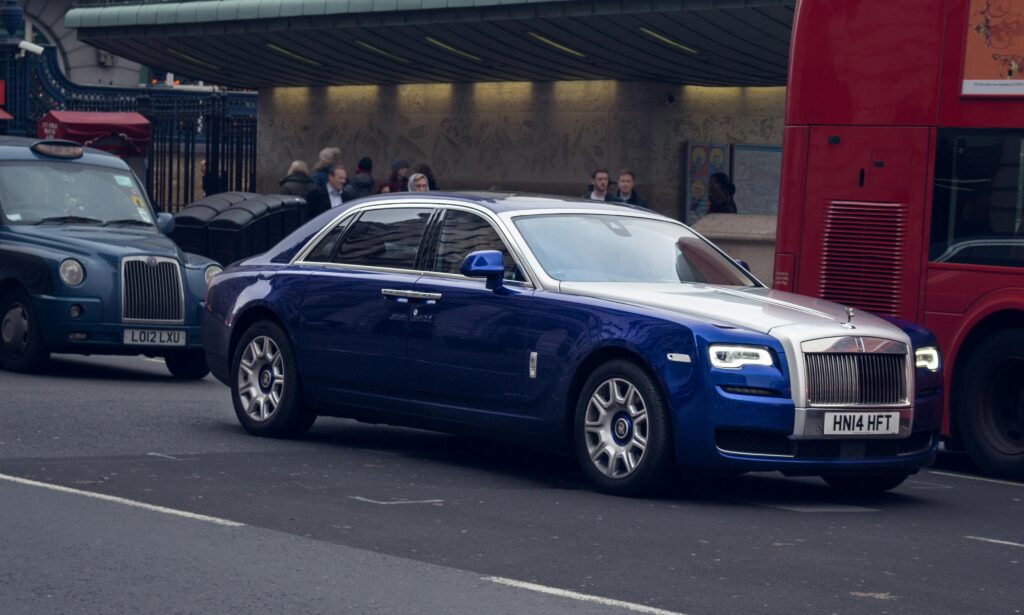 a blue rolls royce car in the road side